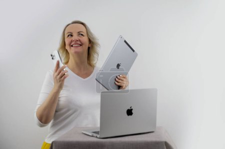 Foto de Mujer de la celebración de Apple gadgets que tiene iPad MacBook y el teléfono que iPhone 13 promax Ella mira a la tableta iPad y sonrisas comprar regalos compra venta publicidad última tecnología Ucrania 2023 - Imagen libre de derechos