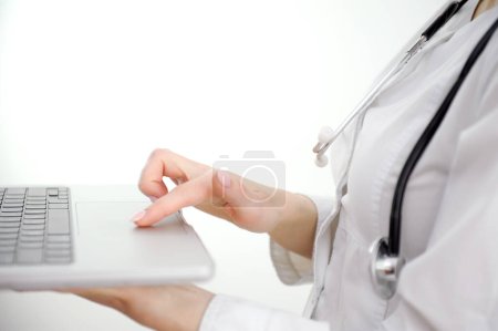 Nahaufnahme einer Ärztin, die am Laptop arbeitet, auf der Tastatur tippt, Therapeutin, Krankenschwester am Arbeitstisch im Krankenhausbüro sitzt, medizinische Apps nutzt, online berät, Bericht schreibt. Hohe Qualität 