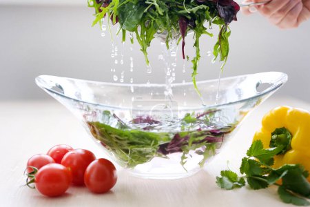 Photo for Pour water and wash vegetables greens cooking delicious healthy food cleanliness kill germs refresh clean the kitchen Super Slow Motion Shot of Flying Cuts of Colorful Vegetables and Water Drops - Royalty Free Image
