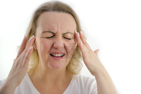Foto de Mujer vieja con dolor de cabeza sostiene sus manos a sus sienes Mujer atractiva que tiene un dolor de cabeza sobre fondo blanco. Foto de alta calidad - Imagen libre de derechos