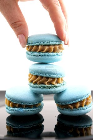 Téléchargez les photos : Fille pose macarons bleu et rose pour prendre une photo sur fond gris. Macarons sur fond gris, biscuits français colorés macarons. Mise en page créative faite de macarons colorés. Concept alimentaire. - en image libre de droit
