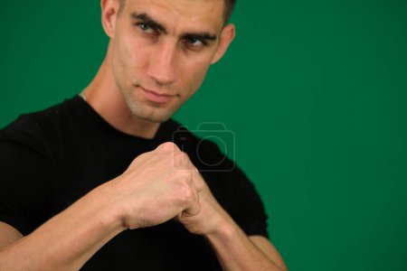 Foto de Emociones de un hombre guapo en un fondo verde cromakey primer plano pelo oscuro joven - Imagen libre de derechos