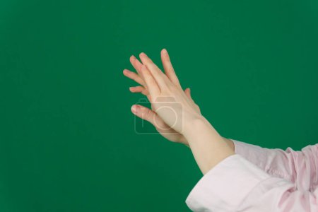 Téléchargez les photos : Une femme mains étalant la crème sur la paume de sa main vers le pinceau. Mains toilettées, ongles courts naturels, sur un fond clair. Photo de haute qualité - en image libre de droit