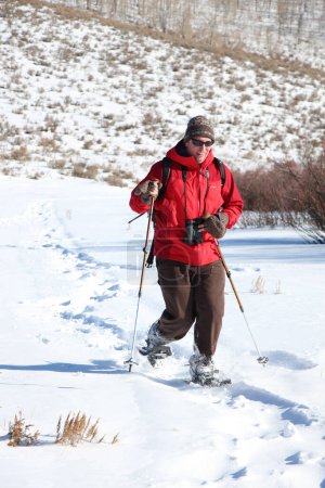 Photo for Man in red jacket snow shoeing - Royalty Free Image