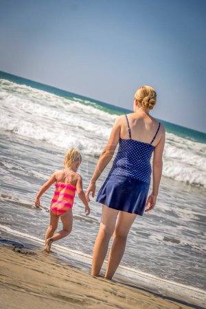 Photo for Mother and Daughter Standing on Shoreline at the Beach - Royalty Free Image