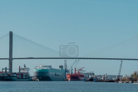 Foto de Savannah, Georgia, Estados Unidos. 2 de diciembre de 2022: Puente conmemorativo de Talmadge con cielo azul y barcos en el río Savannah. - Imagen libre de derechos