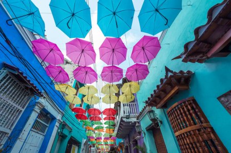 Photo for Cartagena, Bolivar, Colombia. March 15, 2023: Getsemani neighborhood Calle de la Magdalena decorated with colorful umbrellas and drawings. - Royalty Free Image