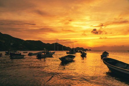 Paisaje con hermosa puesta de sol en el mar y barcos en la orilla. Playa Taganga. Santa Marta, Colombia. 
