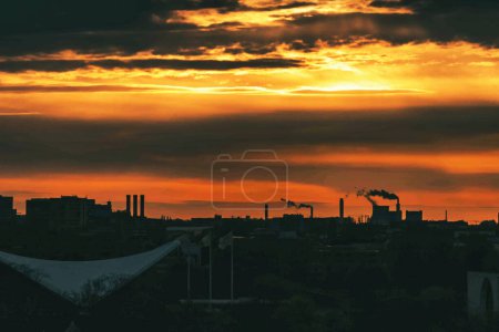 Foto de Puesta de sol con siluetas de máquinas en la zona industrial de Alemania. - Imagen libre de derechos