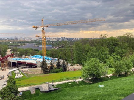 Photo for Construction site, three tall tower cranes and blue building materials. Memorial to the victims of the Holodomor in Ukraine. A view of the construction site of the new complex - Royalty Free Image