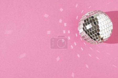 Foto de Bola de disco sobre fondo rosa pastel. El concepto de entretenimiento mínimo. Puesta plana. - Imagen libre de derechos