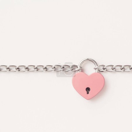 Téléchargez les photos : Composition Fond Saint-Valentin avec coeur rose est attaché avec une chaîne et un cadenas. Concept minimal de Saint-Valentin ou d'amour. Art créatif, esthétique minimale.Vue de dessus. Pose plate - en image libre de droit