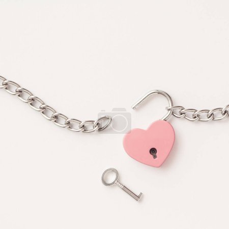 Photo for Minimal concept of Breaking up a love relationship. Family divorce. Family happiness. The pink heart is tied with a chain and a padlock. Love concept. - Royalty Free Image
