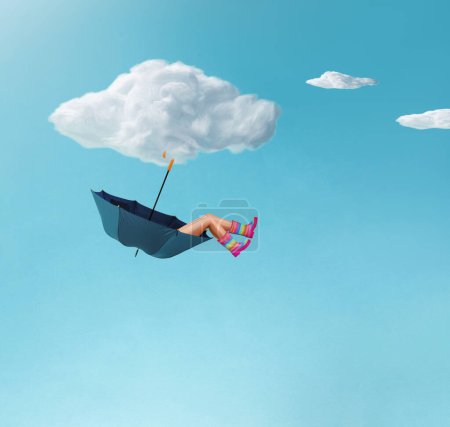 Foto de Composición hecha de una niña con coloridas botas de goma que yacen en un paraguas unido a una nube. Concepto mínimo de momento surrealista, arte creativo, estética mínima. - Imagen libre de derechos
