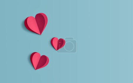 Téléchargez les photos : Concept minimal de la Saint-Valentin ou de l'amour fait de coeurs de papier rouge sur un fond de couleur bleu pastel Art du papier créatif, esthétique minimale, bannière Love avec espace pour le texte - en image libre de droit