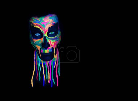 Foto de Máscara de cráneo con color UV vívido. Un concepto espeluznante. Concepto de Halloween o Santa Muerte. Fondo retro del futuro con luz negra. - Imagen libre de derechos