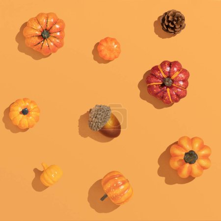 Photo for Trendy Autumn sunny composition made with pumpkins and seasonal fruits, on sunlit orange pastel background with sharp shadows. Flat lay harvest or halloween concept. - Royalty Free Image