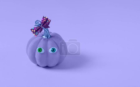 Foto de Calabaza de Halloween púrpura con maquillaje y ojos coloridos. Antecedentes del concepto de temporada mínima de vacaciones. - Imagen libre de derechos