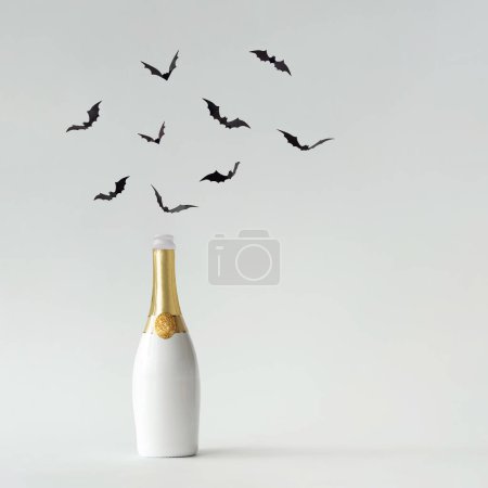 Téléchargez les photos : Aménagement contemporain réalisé avec bouteille de champagne blanche et or avec silhouettes de chauves-souris - en image libre de droit