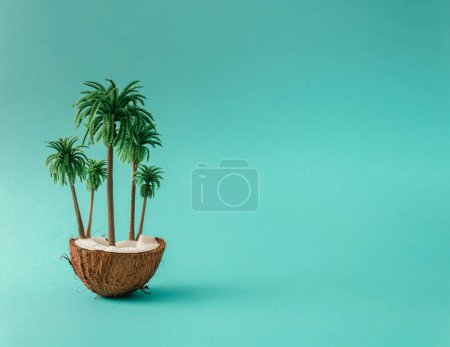Foto de Isla tropical de coco con hojas de palma sobre fondo azul. Concepto de playa tropical hecho de frutas de coco y palmeras. Creativa idea mínima de verano. - Imagen libre de derechos