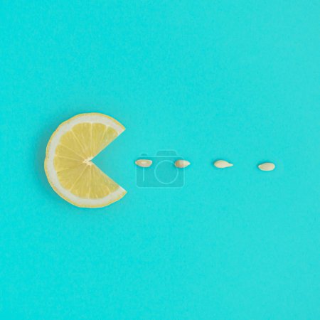 Téléchargez les photos : Trancher le citron avec des graines sur un fond bleu. Art créatif d'été. Minimale esthétique agrumes. Couché plat, vue du dessus. - en image libre de droit