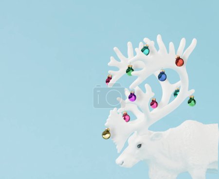 Foto de Concepto creativo de Navidad hecho con renos blancos de Navidad con astas con adornos navideños y adornos decorativos sobre fondo azul pastel - Imagen libre de derechos
