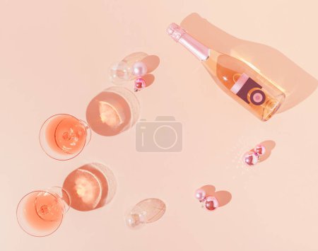 Photo for Creative flat lay with white and pink champagne bottle and Christmas decoration against apricot color background. Retro aesthetic style. New Year party background. - Royalty Free Image