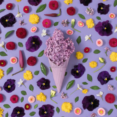 Téléchargez les photos : Cône de crème glacée avec lilas violet et fleurs et feuilles jaunes. Concept minimal d'été. Pose plate. - en image libre de droit