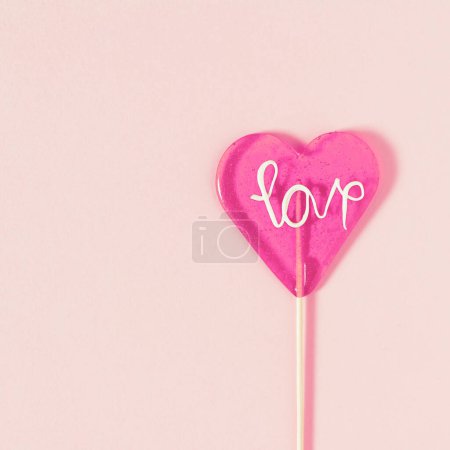 Photo for Pink Valentine's day heart shape lollipop candy on empty pastel pink background - Royalty Free Image