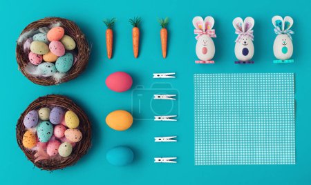 Téléchargez les photos : Modèle de Pâques fait avec des œufs de Pâques colorés, sur un fond bleu pastel. Concept minimal de Pâques. Art créatif, esthétique minimale. Pose plate. Espace d'écriture, espace de copie - en image libre de droit