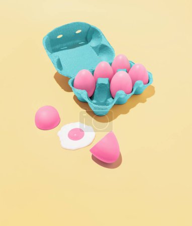 Foto de Composición abstracta de moda hecha de huevos de Pascua rosados y una caja azul sobre un fondo amarillo pastel - Imagen libre de derechos
