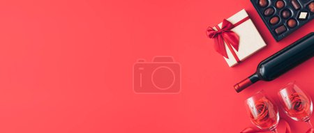 Foto de Composición Fondo de San Valentín con botella de vino, caja de regalo, vasos y caja de chocolates. Concepto mínimo de San Valentín o amor. Arte creativo, estética mínima. Vista superior. Puesta plana - Imagen libre de derechos