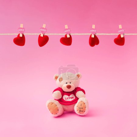 Téléchargez les photos : Composition d'amour faite d'ours en peluche et tenant un cœur en forme sur fond rose pastel. Concept minimal de Saint-Valentin ou d'amour. Art créatif, esthétique minimale. - en image libre de droit