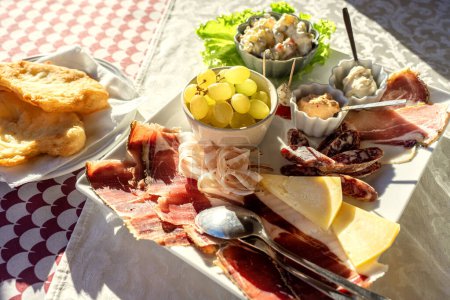 antipasti plate in Slovenia Groznjan with air dried ham cheese and fruits .
