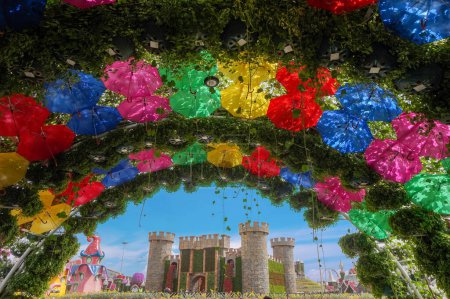 bright floral und umbrella arch with a flower castle in the Miracle Garden in Dubai .