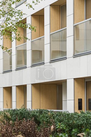 Foto de Detalle de un edificio multifamiliar en el centro de la ciudad. Gran número de pisos. Balcones y loggias. Sol en la ciudad - Imagen libre de derechos
