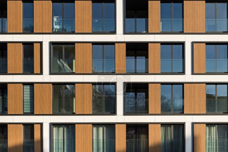 Foto de Detalle de un moderno edificio multifamiliar en el centro de la ciudad. Gran número de pisos. Balcones y loggias. Clima soleado - Imagen libre de derechos