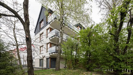 Detail für Fassaden und Balkone in einem modernen Mehrfamilienhaus in einer europäischen Stadt. Interessante Architektur. Zwischen Vegetation und Bäumen. Blühender Frühling