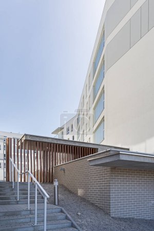 Foto de Detalle de un moderno edificio multifamiliar en una ciudad europea. Interesante disposición de ventanas y material. Losas de madera. Zona de entrada - Imagen libre de derechos