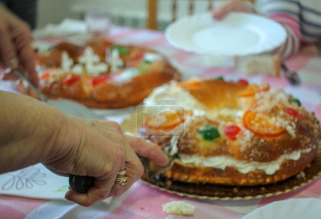 Servieren einer Scheibe Roscon de Reyes oder Dreikönigskuchen in Spanien zu Weihnachten