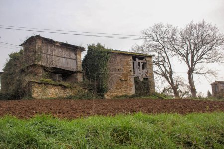 antigua casa abandonada en Galicia, España, con un granero cerca de ella