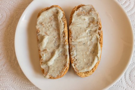 Téléchargez les photos : Vue aérienne des rouleaux entiers grillés tartinés de crème au fromage Cabrales sur une assiette, accompagnés d'une serviette en toile de fond. Combinaison de saveurs et de textures dans les plats espagnols traditionnels. - en image libre de droit