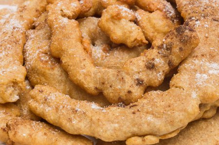 Photo for A close-up of a Spanish funnel cake covered with powdered sweetener and cinnamon powder. Traditional desserts, snacks, and food. - Royalty Free Image