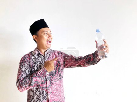 A Muslim man points to a drinking water bottle