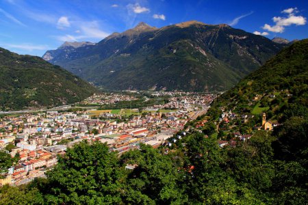 Photo for Landscape with a view of the mountains, the town of Bellinzona at their feet and the small yellow church, in Bellinzona, near Locarno, in southern Switzerland - Royalty Free Image