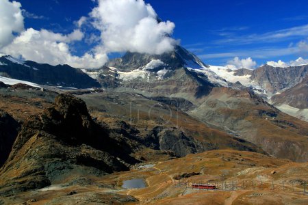 Photo for Landscape with the Matterhorn mountain, partially covered by clouds, and a small lake at its foot, on the Gornergrat mountain, near Zermatt, Switzerland - Royalty Free Image