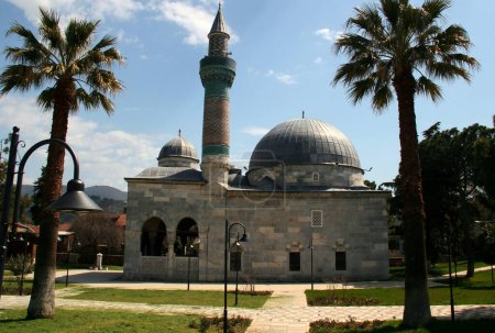 Foto de Foto de una vista de la mezquita Yesil Camii con un minarete verde rodeado de altas palmeras en la parte histórica de Iznik, Turquía - Imagen libre de derechos