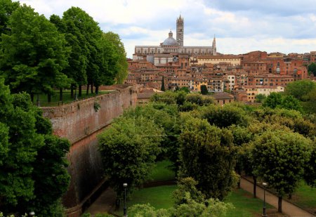 Photo for View of the historic part of the city of Siena with the Duomo di Siena in the center of the photo and the walls and park of the Fortezza Medicea in the foreground in the Tuscany region of Italy - Royalty Free Image