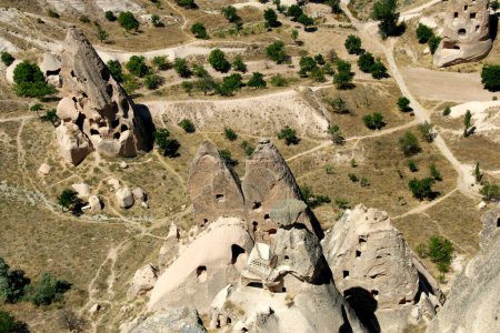 Photo for Aerial view of cone-shaped mountains (also called Fairy Chimneys) with caves inside in the town of Uchisar, near Goreme in Cappadocia, Turkey - Royalty Free Image