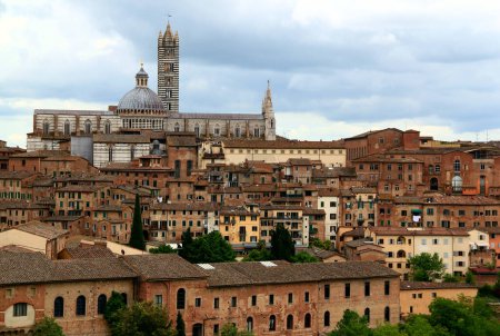 Photo for View of the historic part of the city of Siena with the Duomo di Siena against a stormy sky in the Tuscany region of Italy - Royalty Free Image